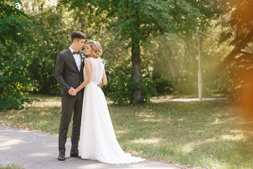 Bride and groom. Portrait of a man in a suit and a woman of a blonde in a white dress on nature on the wedding day.