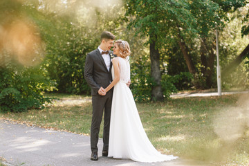 Bride and groom. Portrait of a man in a suit and a woman of a blonde in a white dress on nature on the wedding day.
