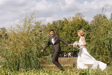 Bride and groom. Portrait of a man in a suit and a woman of a blonde in a white dress on nature on the wedding day.