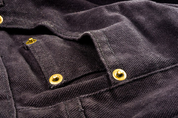 clothing items stonewashed cotton fabric texture with seams, clasps, buttons and rivets, macro