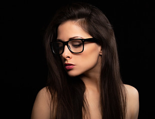 Beautiful makeup woman in eye glasses looking down with long hair on black background. Closeup portrait. Art.Expression portrait.