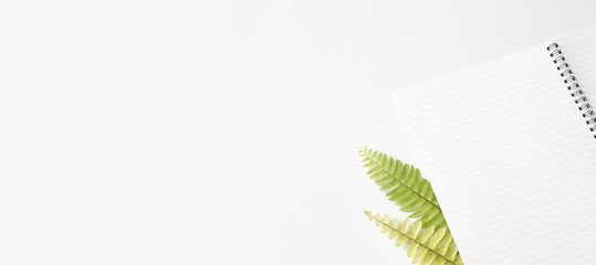 Flat lay, Office desk working space with notepad, leaf and notebook.Top view with copy space for text or image.background working desk concept.