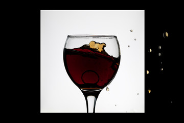 glass of red wine in a black and white frame with droplets and ring in the glass