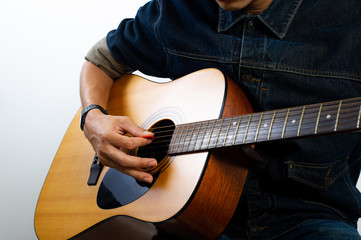 Fototapeta premium The acoustic guitarist is holding the guitar. And playing guitar Concepts of hobbies and relaxation in free time for good quality of life