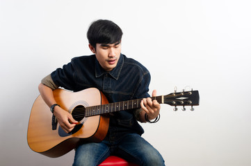 Obraz premium The acoustic guitarist is holding the guitar. And playing guitar Concepts of hobbies and relaxation in free time for good quality of life