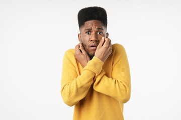 Portrait of scared man. Young man standing isolated on white studio background