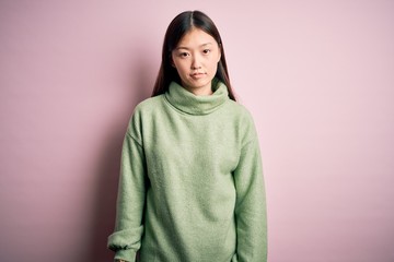 Young beautiful asian woman wearing green winter sweater over pink solated background looking sleepy and tired, exhausted for fatigue and hangover, lazy eyes in the morning.