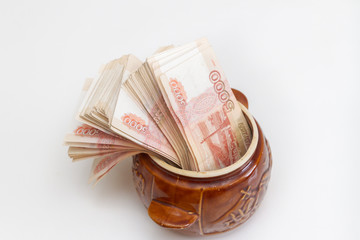Russian banknotes of five thousand rubles in large quantities in a ceramic pot
