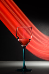 Wine glass with neon red trail on background