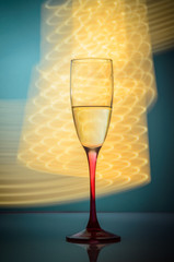 glass of champagne with yellow neon lights on a blue background