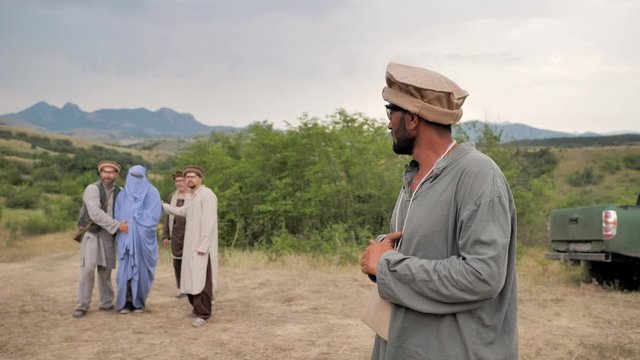 Mountains of Afghanistan. Pregnant woman with men in the Afghan national clothes