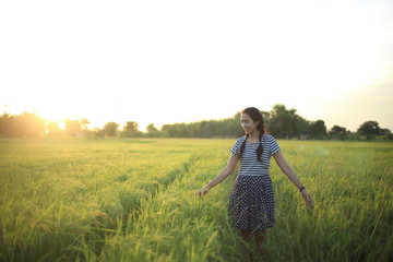 A woman standing in a rice field in Rayong, Thailand