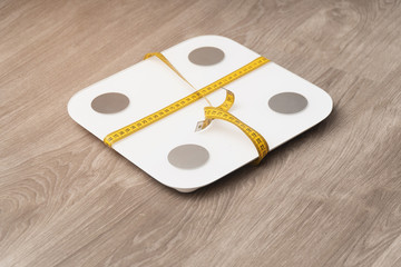 closeup measuring control scales tied with a centimeter tape. slimming and obesity control concept
