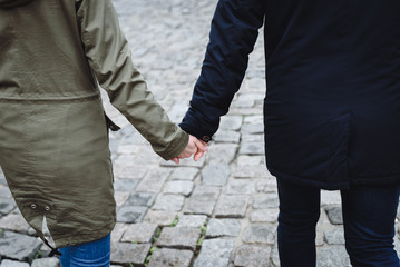 a couple walking in the street holding their hands