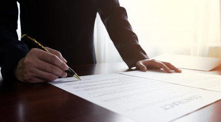 Close up businessman or manager signing documents contract paper, lease mortgage, partnership...