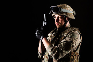 Soldier with gun is on mission on black background. Concept of war.