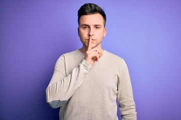 Young handsome caucasian man wearing casual sweater over purple isolated background asking to be quiet with finger on lips. Silence and secret concept.