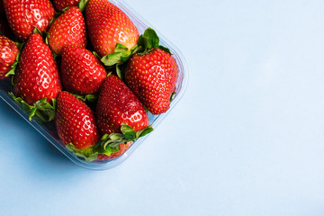 Bowl of strawberries on blue background
