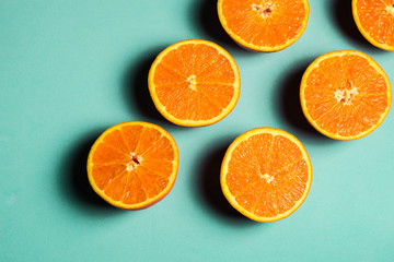 Set of oranges cut in half on aqua blue background
