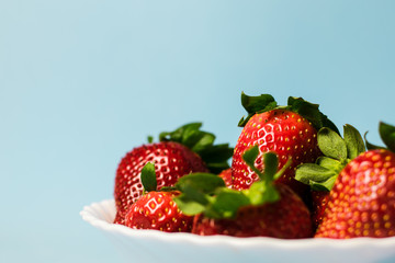 Bowl of strawberries on blue background
