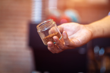Barista show coffee beans in drip glass.
