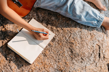 songwriter create and writing notes,lyrics in the book on stone at parks.