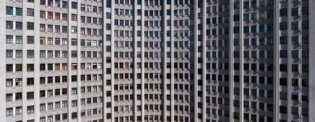 Many windows on modern gray building. Closeup