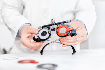 Optometrist holding optical trial lens frame, optical equipment 