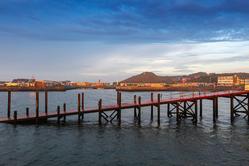 Heligoland - harbor with pier and colorful houses at sunrise with dramatic  beautiful sky.