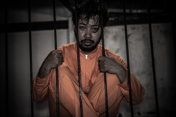 Asian man desperate at the iron prison,prisoner concept,thailand people,Hope to be free,Serious...