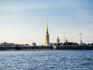 Peter and Paul Fortress illuminated by the sun against a blue sky - 345698285