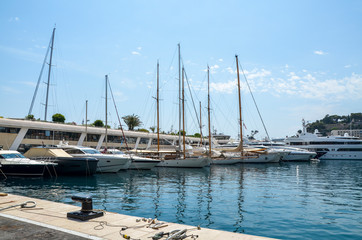 Fototapeta premium Luxury elegant yachts dropped anchor in seaport on a beautiful summer day in Monte Carlo, Monaco, French Riviera
