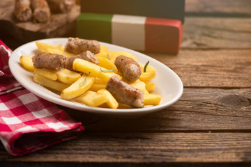 White plate of  italian sausage and potatoes