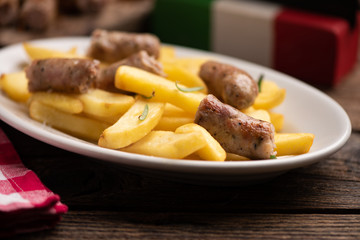 White plate of  italian sausage and potatoes