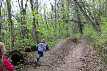 Boy and girl running or hike through the forest in early spring