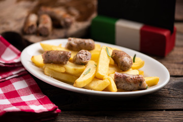 White plate of  italian sausage and potatoes
