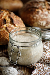 Rye sourdough bread in a jar on a wooden table, active Rye sourdough in glass jar, sourdough starter