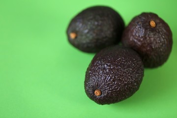 Avocado fruit. Three ripe avocados  set on a light green background.Useful dietary product. Healthy Fat. Organic Bio Fresh Avocado