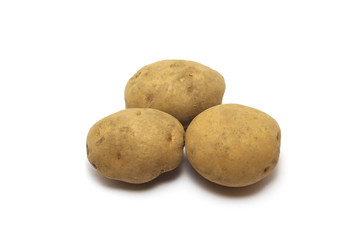 Three unpeeled potatoes (Solanum tuberosum) shot on top high angle isolated on white background