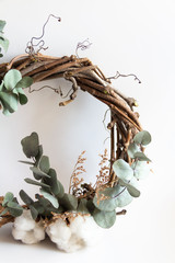 Obraz na płótnie Canvas handmade wreath made of twigs, eucalyptus and cotton