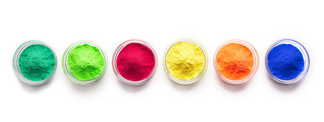 Bright red, blue, green and yellow food powder on white background