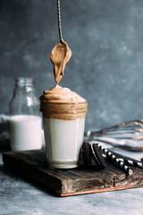 Dalgona coffee in a glass. Korean coffee and milk drink.