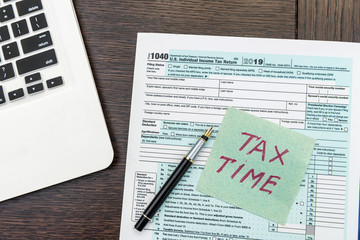 Financial time tax form with laptop and calculator. Office paperwork