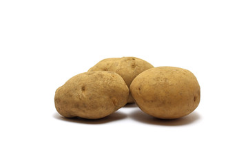 Three unpeeled potatoes (Solanum tuberosum) shot on low angle isolated on white background