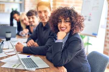 Group of business workers sitting in line with smile on face. Looking at the camera, young beautiful woman smiling at the office
