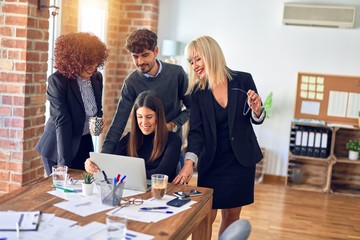 Group of business workers smiling happy and confident. Working together with smile on face  using laptop at the office
