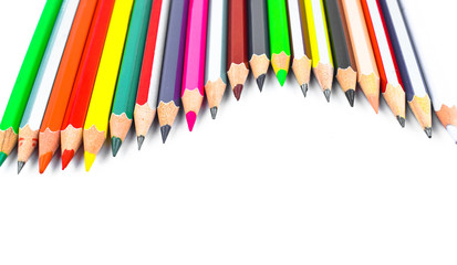 Wave gesture of a row of different color wood pencil crayons on a white background