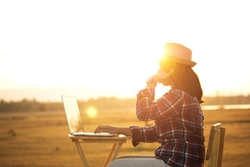 Businesswoman working on laptop is outside in early morning, she is young and attractive girl. Work from anywhere lifestyle. Freedom, freelance