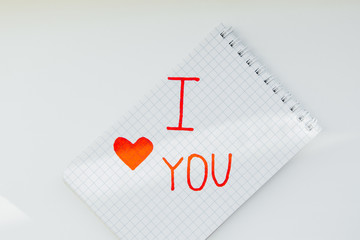 Notepad on a white background with text i love you