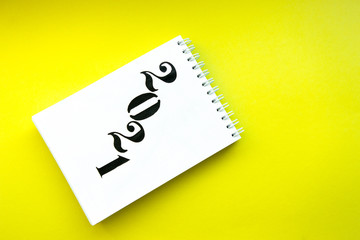 Notebook with white pages on yellow background. Notebook with text 2021. Targets for future year